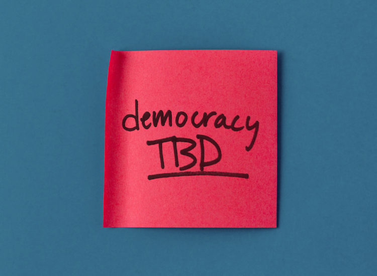 A red post-it note showing the title of the project, "Democracy TBD"