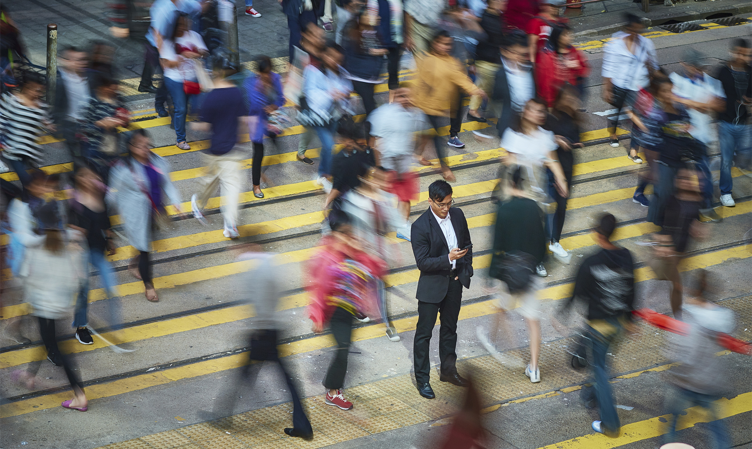 Businessman using smart phone amidst crowd